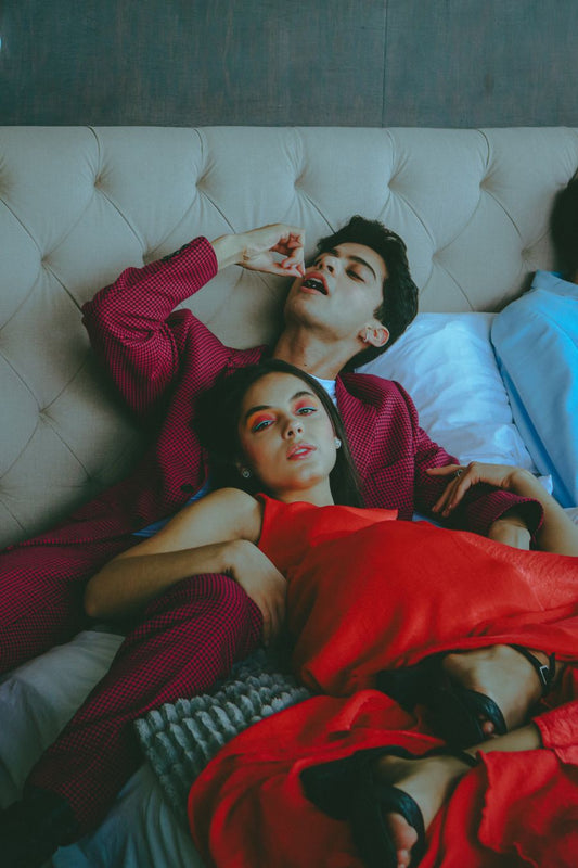 Stylish couple lounging playfully together on a plush bed